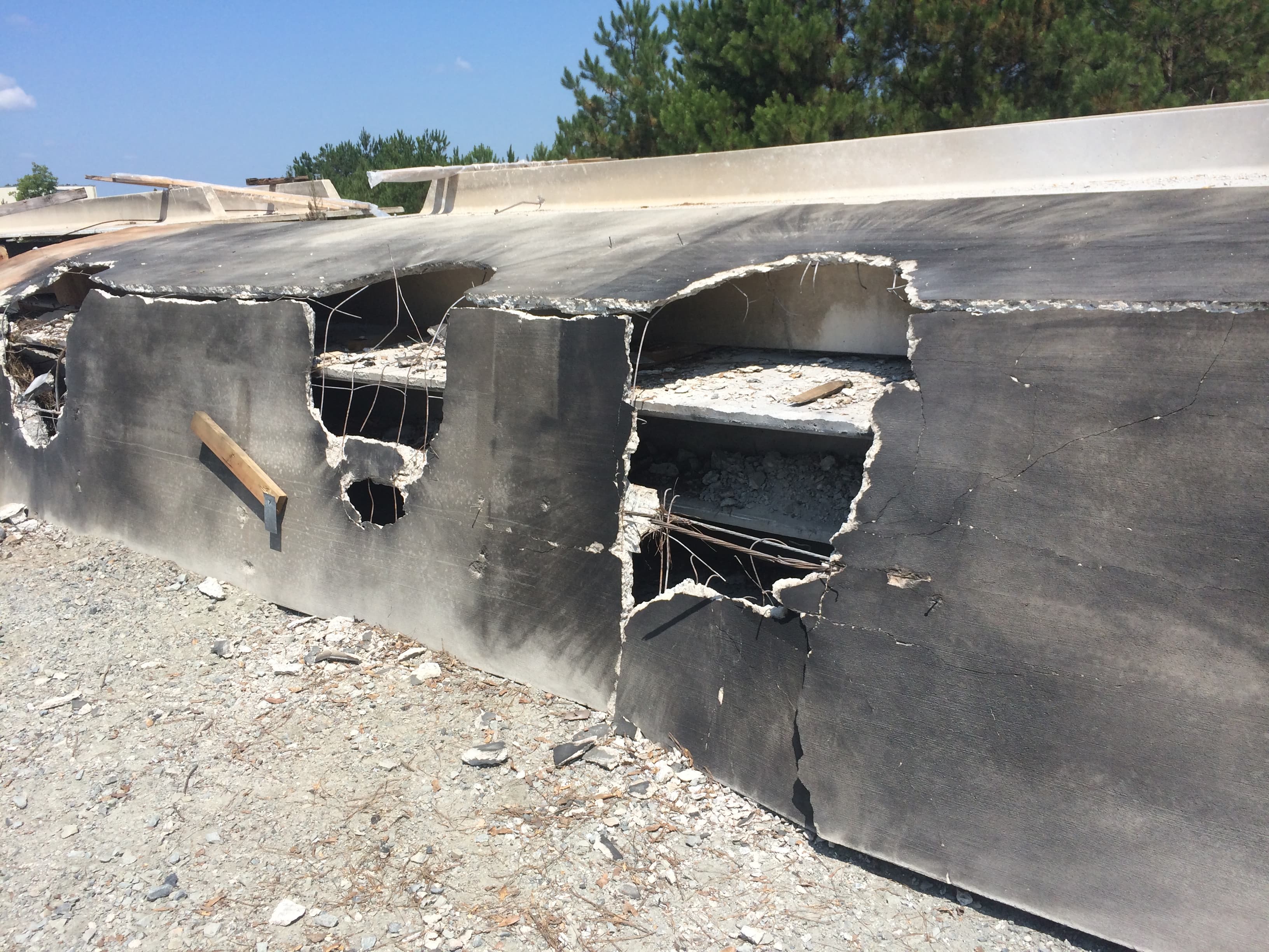 A steel-plated test wall with jagged holes blown through it on the explosives range.