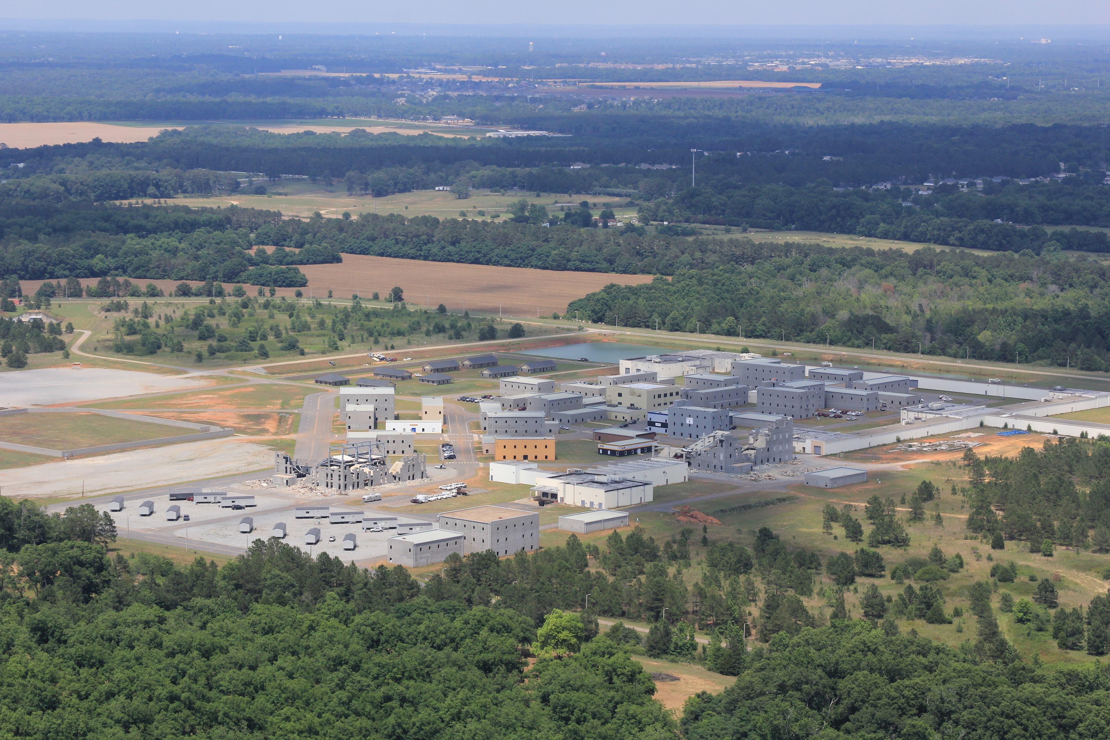 Aerial view of the Guardian Centers training campus, its multi-story buildings and lots surrounded by woodland.