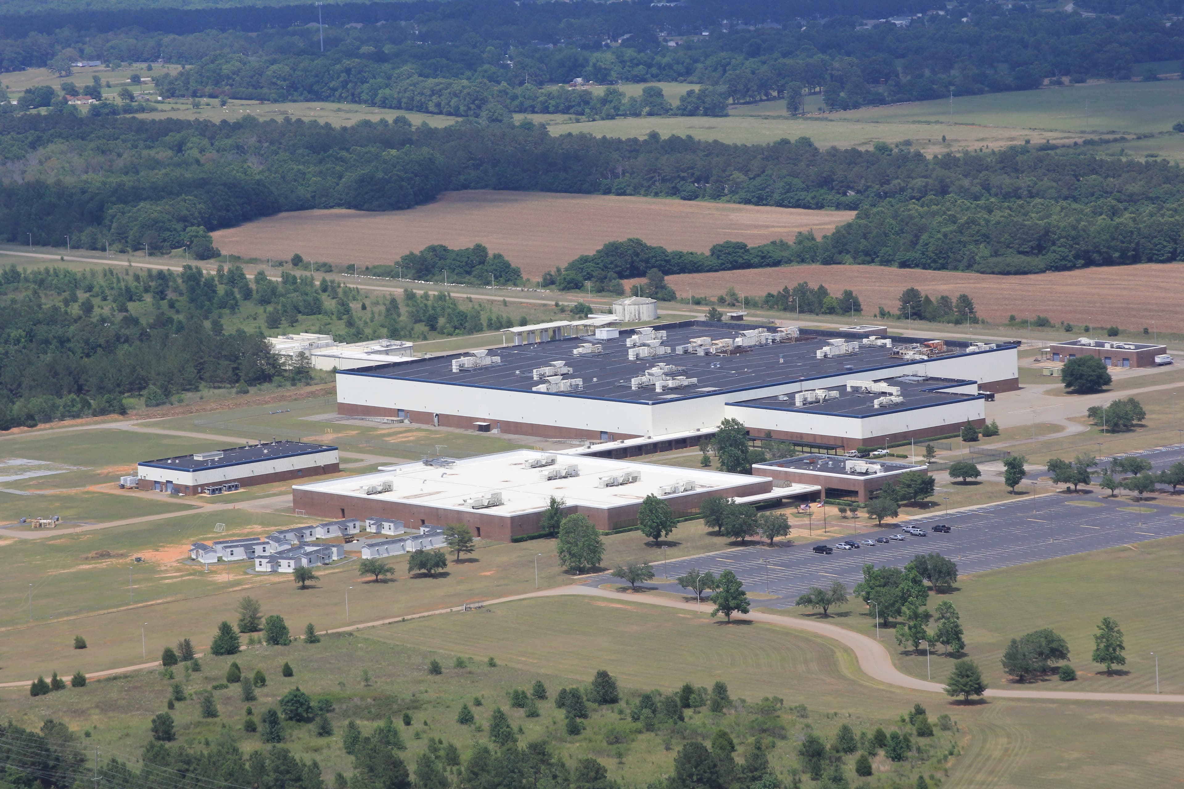 Aerial view of the Guardian Centers headquarters and warehouse buildings set among fields and pine woods.